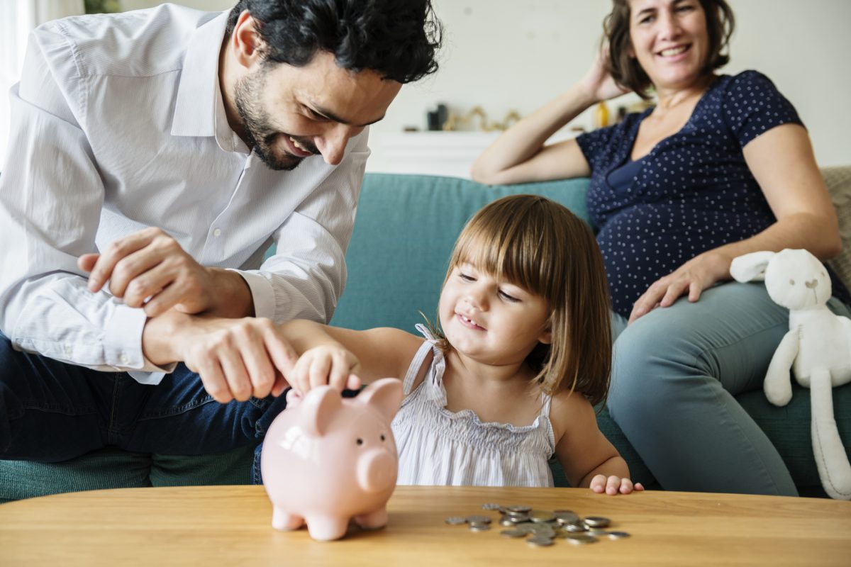 family budgeting on couch, piggy bank, counting money, young girl