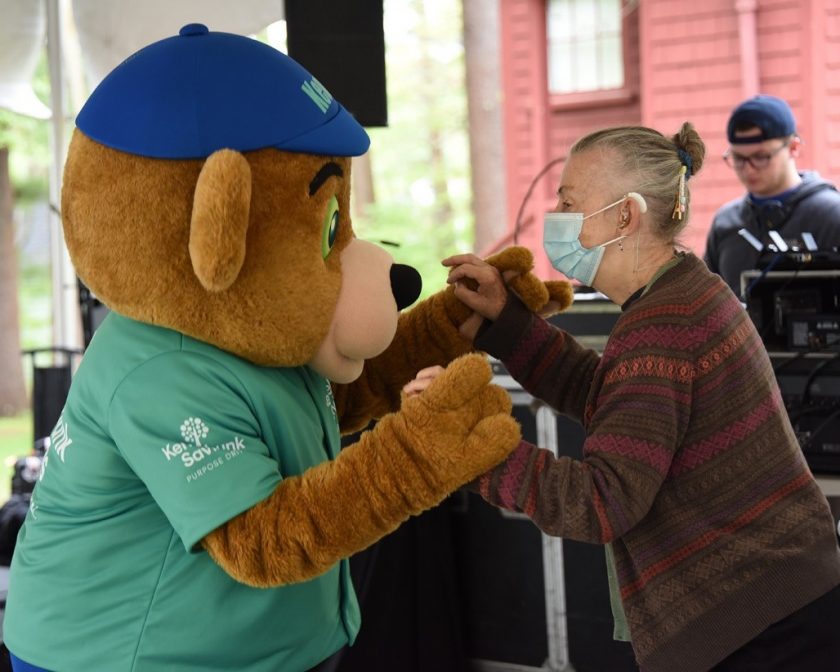 Kennebunk Savings mascot dancing to music with a woman at Waban Telefest event.