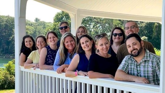 The Kennebunk Savings Marketing team poses for a group photo on the porch at Carey Cottage in Portsmouth.