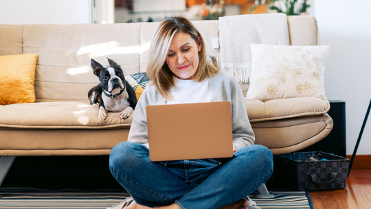 woman on computer with dog on couch