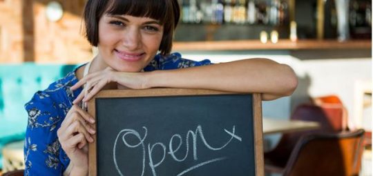 woman standing in front of open sign