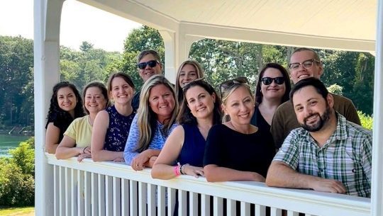 The Kennebunk Savings Marketing team poses for a group photo on the porch at Carey Cottage in Portsmouth.